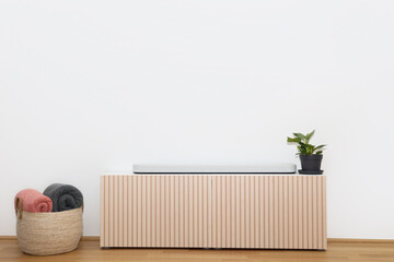 Poster - Stylish TV stand, houseplant and basket with plaids near light wall