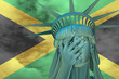 Statue of Liberty. Facepalm emoji on background in colors of Jamaica flag