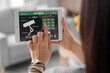 © Pixel-Shot - Young woman using smart home security system control panel, closeup