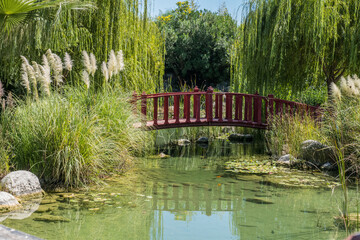 Poster - old wooden arch bridge in japanese zen garden