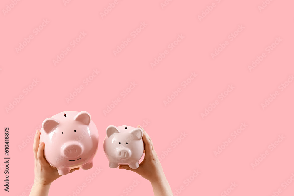 Woman with piggy banks on pink background