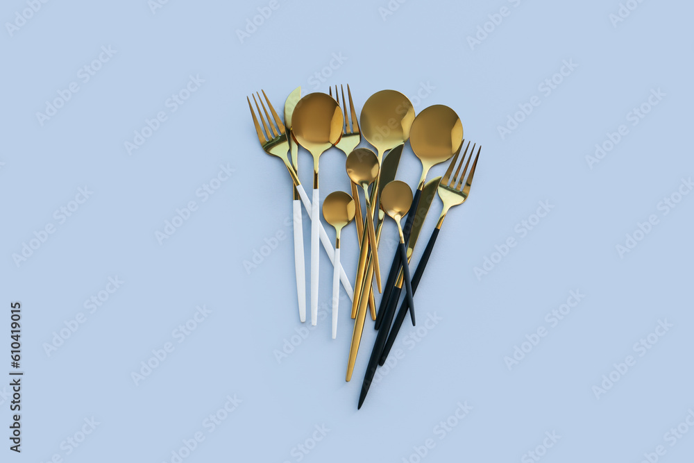 Golden cutlery on blue background