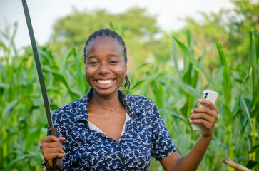 female african farmer using her phone. african farmer checks her mobile phone, texts and chat