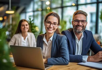 A team of professionals, both men and women in a modern office, showcasing their enthusiasm and camaraderie as they pose for a group photo while working on laptops. generative AI.