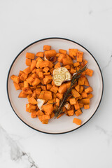 Wall Mural - Baked sweet potato slices in a plate on the table. Healthy eating. Vegan dish.