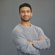 © Delcio Fernandes/peopleimages.com - Portrait of happy man with mockup, arms crossed and ideas on studio backdrop in casual fashion. Relax, confidence and face of male on grey background with happiness, pride and smile with promo space.