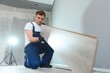 © Serhii - DIY, repair, building and home concept - man lying parquet floor board or laminate flooring