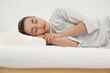 © New Africa - Woman sleeping on memory foam pillow indoors