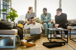 © Maskot - Multiracial male and female colleagues discussing over laptop in creative office