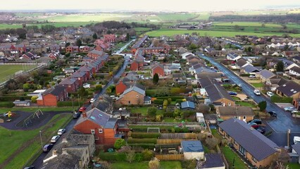 Wall Mural - Aerial drone footage of the village of Emley in West Yorkshire, England, located between Huddersfield and Wakefield, showing the residential houses on a cold winters day in the autumn time.