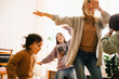 © Maskot - Happy woman dancing and enjoying with children at home