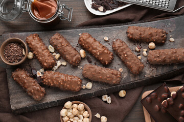 Canvas Print - Tasty chocolate bars with caramel and nuts on wooden table, flat lay