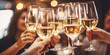 © Jasmina - Close up of group of friends toasting with glasses of white wine at restaurant