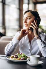 Canvas Print - Business woman working on laptop and eating salad