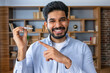 © Ivan - Young arab man with beard holding invisible aligner orthodontic and braces and pointing at it, recommending this new treatment. Dental healthcare concept.
