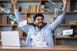 © Ivan - Happy financier man sitting in office and holding dollars. Man throwing out money.