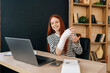 © dikushin - Cheerful young woman with broken right hand wrapped in white gypsum bandage having online video call, smiling looking to screen, working remotely on laptop computer sitting at desk in home office room