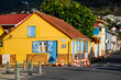Street view panorama of picturesque creole village “Les Anses-d'Arlet“ with colorful wooden houses and tropical vegetation. Idyllic popular holiday destination on caribbean island Martinique, France.