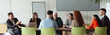 © .shock - Wide crop photo of a diverse group of business professionals, including an person with a disability, gathered at a modern office for a productive and inclusive meeting.