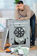 © auremar - disappointer man repairing washing machine