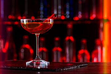 Cocktail with hot chilli pepper on bar counter in a restaurant, pub. Fresh spicy drink. Alcoholic cooler beverage at nightclub on dark background