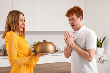 Canvas Print - Young woman with cloche proposing to her boyfriend in kitchen