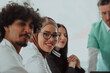 © Minet - A group of multiethnic medical professionals including doctors, surgeons, and nurses are gathered in a hospital setting discussing patient care and using modern technology to address challenges in