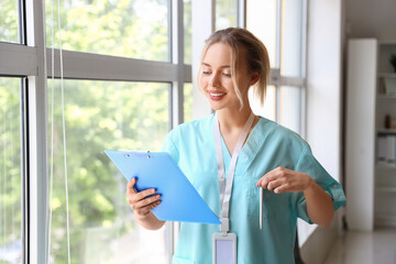 Canvas Print - Female medical intern with clipboard in clinic