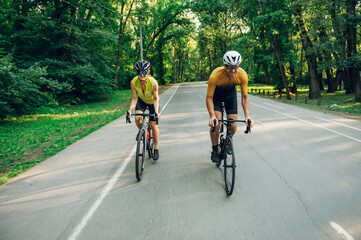 Wall Mural - Couple riding bicycles outside of the city and wearing helmets and sunglasses