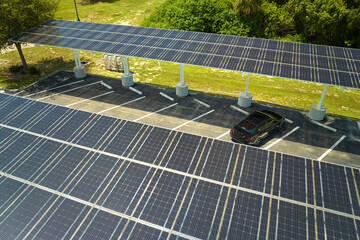 Aerial view of solar panels installed as shade roof over parking lot for parked cars for effective generation of clean electricity. Photovoltaic technology integrated in urban infrastructure