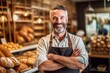 © Leon Waltz - Portrait of smiling mature male baker standing with arms crossed in bakery