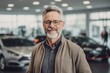 © Robert MEYNER - Medium shot portrait photography of a satisfied man in his 50s that is wearing a simple tunic against a car showroom or dealership background .  Generative AI