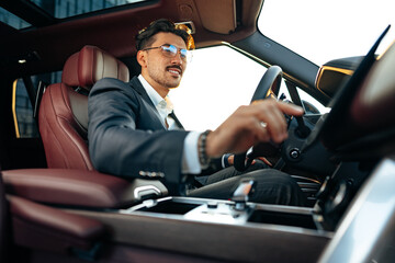 Poster - Young businessman in elegant suit driving luxury car