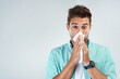 Wipe nose, tissue and portrait of man in studio with flu allergy, sickness and virus on white background. Handkerchief, mockup space and face of male person for hayfever, cold and sneeze for sinus