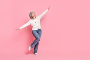 Poster - Full body photo of gorgeous mature grandma hands wings plane fly have fun wear trendy white outfit isolated on pink color background