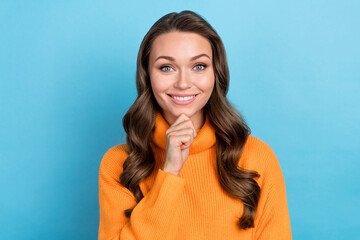 Poster - Photo of sweet cheerful woman dressed orange sweater arm chin smiling empty space isolated blue color background