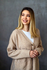 Wall Mural - Portrait of a happy woman posing against a grey background