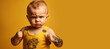 Small tattooed infant boy in a yellow singlet with a serious fighting face. Generative AI