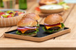 three vegan burgers on a wooden plate