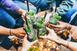 © Nicolas Micolani - Multiracial group of young people cheering Mojito cocktails at bar pub enjoying summer party - Happy friends drinking fancy drinks sitting restaurant table- Food and beverage concept-Youth culture..