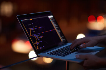 Hacker, programming and laptop with hands of person for ransomware, cyber security and phishing. Coding, technology and crime with closeup of programmer for fraud, network system and data at night