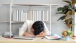 © M Stocker - Exhausted and tired young asian office worker falling asleep on desk because of overtime work hours. Feeling sleepy during working. Taking a nap