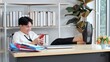 © M Stocker - Young asian man putting feet on table in office while using smartphone enjoy chatting messages in social media, watch internet content take break from work