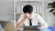 © M Stocker - Young asian businessman confused financial report checking with laptop on desk at office. Serious people from work, Stress problem