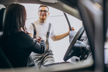 Mechanic with client in car service station