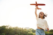 © standret - Happy little girl is playing with toy plane outdoors