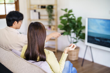 Wall Mural - Asian family Watching smart TV together and using remote controller Hand holding popcorn at home with the remote control movie or TV series spending time at home