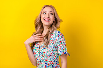 Wall Mural - Photo of adorable dreamy lady wear flower print dress smiling looking back empty space isolated yellow color background