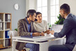 Family couple meeting with bank manager, loan broker, real estate agent or financial advisor. Two people sitting at office desk and having serious conversation with business adviser or bank worker