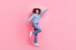 © deagreez - Full length photo of carefree excited woman dressed blue sweatshirt jumping high rising hands isolated pink color background